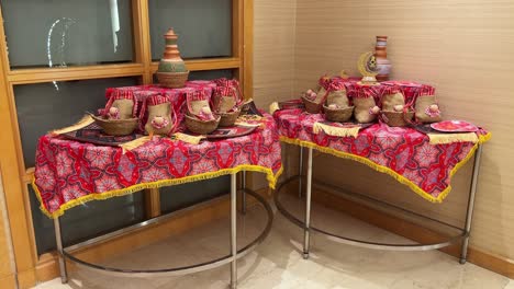 4k footage of traditional ramadan gifts arranged on vibrant red arabic textiles with clay vases and decor—ideal for ramadan promos, middle eastern culture, and hospitality visuals.
