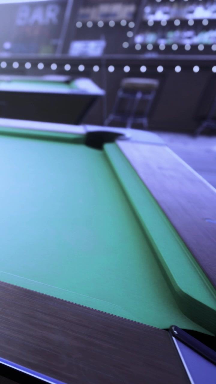 Mesa de bilhar em uma sala de jogos durante a noite, sem jogadores presentes