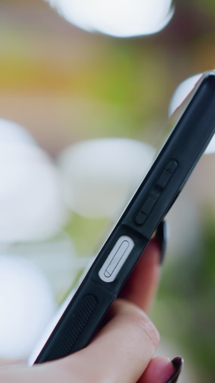 primo piano di un telefono in funzione, con effetti di luce bokeh vibranti sullo sfondo sfocato, creando una sensazione moderna e dinamica, il profilo laterale del telefono è visibile