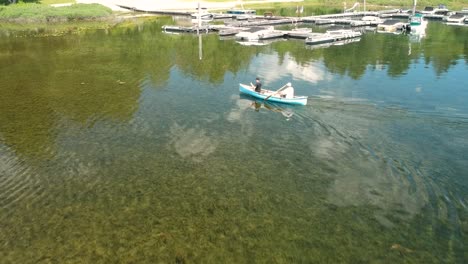 two men canoeing on a lake with dock in background