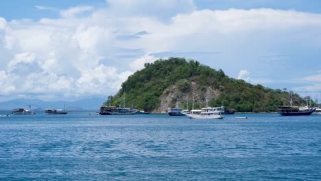 Liveaboard-Boote-Und--Schiffe,-Die-Im-Wunderschönen-Blauen-Ozean-Mit-Tropischen-Inseln-Im-Hintergrund,-Labuan-Bajo,-Insel-Flores-In-Indonesien-Festgemacht-Und-Gekreuzt-Werden