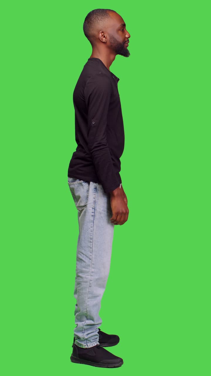 Video verticale: profilo di persona amichevole e alla mano che posa a figura intera su greenscreen