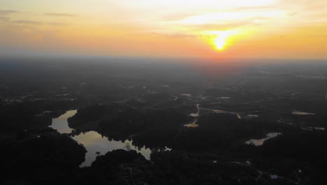 Amazing-cinematic-4K-sunset-residential-drone-footage-after-deforestation-issue-consists-of-homes,-road,-trees,-lake-and-infrastructure-in-the-middle-of-tropical-forest-located-in-Riau,-Indonesia