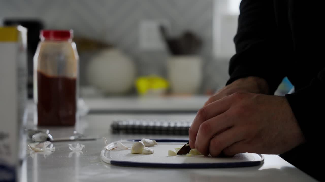 Close-up view of hands chopping garlic with knife for the delicious Beef Qebapa. Traditional Albanian Dish