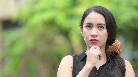 young beautiful asian businesswoman thinking in the streets outdoors