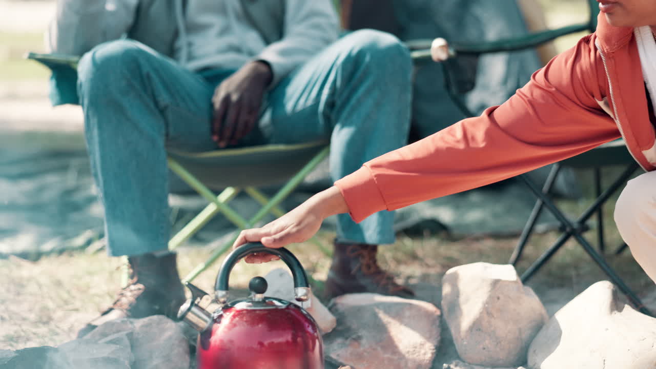 People camping by the campfire making tea