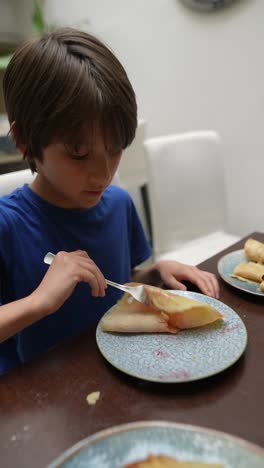 child eating pancakes