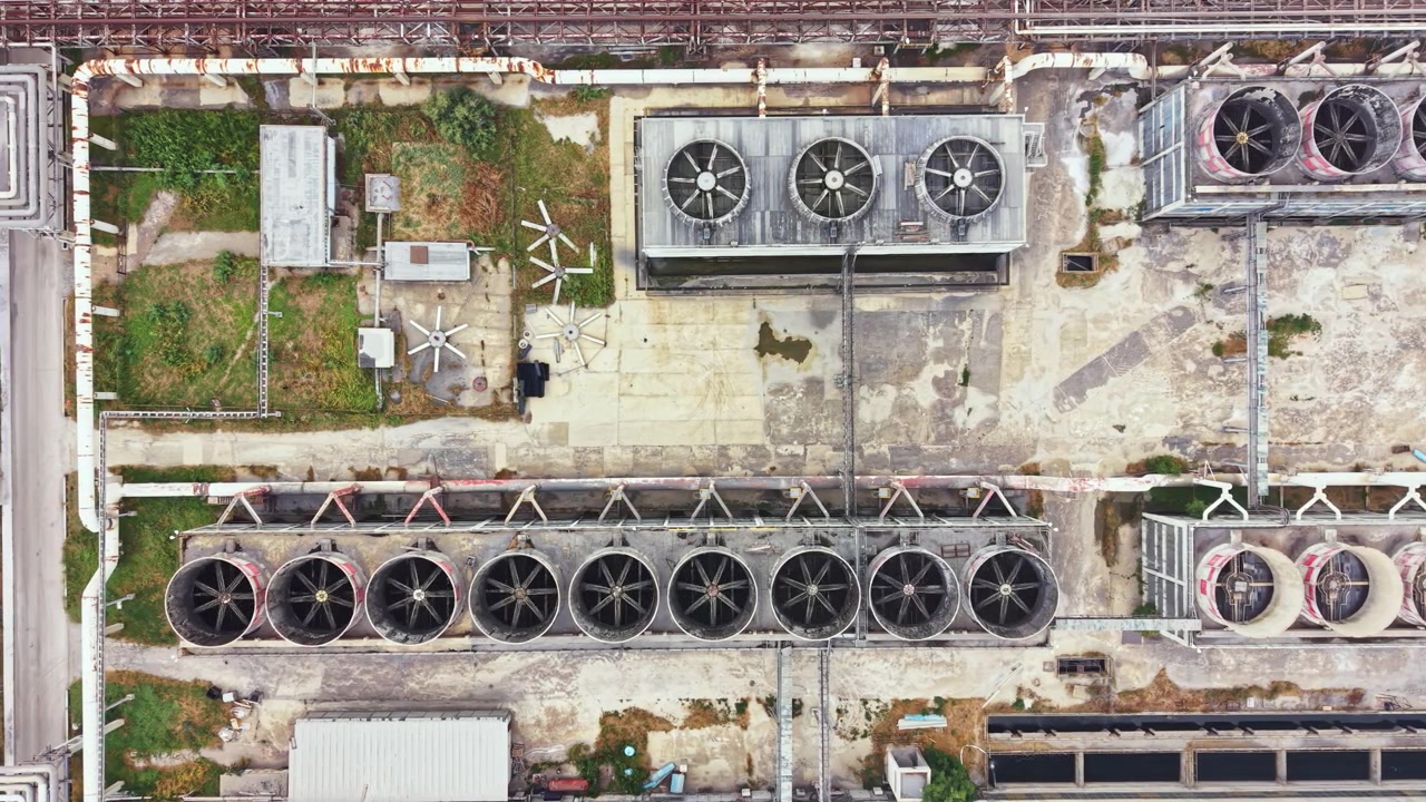 View of cooling towers and rooftop equipment in an industrial area during daylight hours