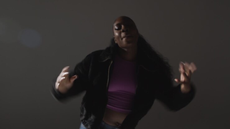 Studio Portrait Shot Of Young Woman Dancing With Low Key Lighting Against Grey Background 10