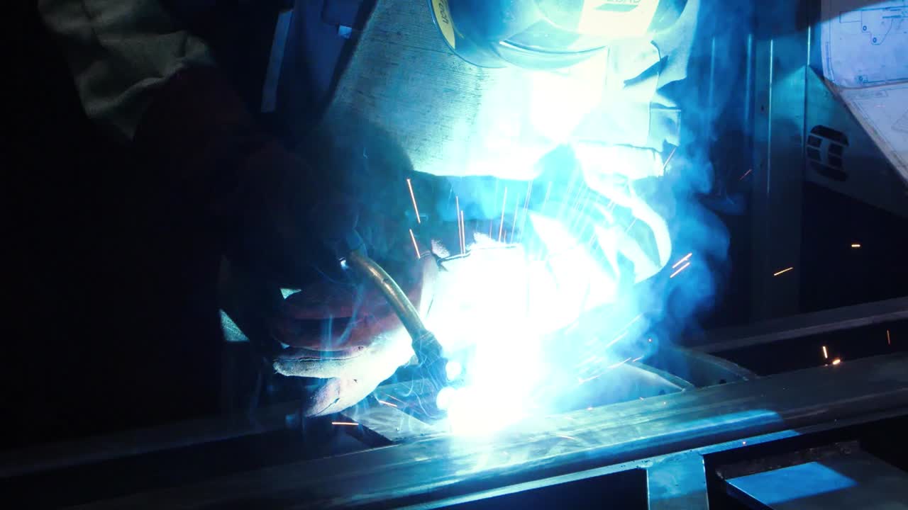 어 ⁇  속에서 날아가는 노란색 불꽃으로 용접하는 위험한 산업 작업