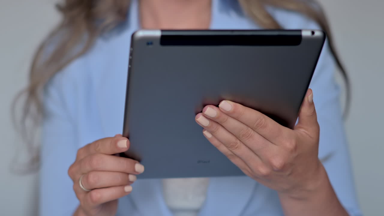 Woman in blue suit working on a tablet in an office