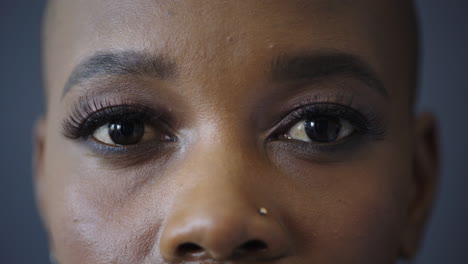 close-up de una hermosa mujer negra ojos abiertos mirando a la cámara usando maquillaje nariz perforación