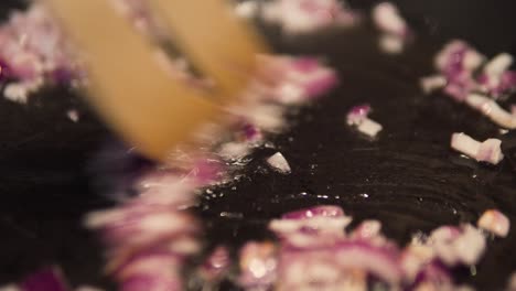 close up of red onions cooking and boiling in pan