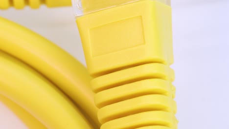 close up view of yellow ethernet cable rotating on white surface, close up view