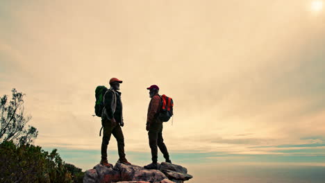 two men hiking on a mountain with backpacks