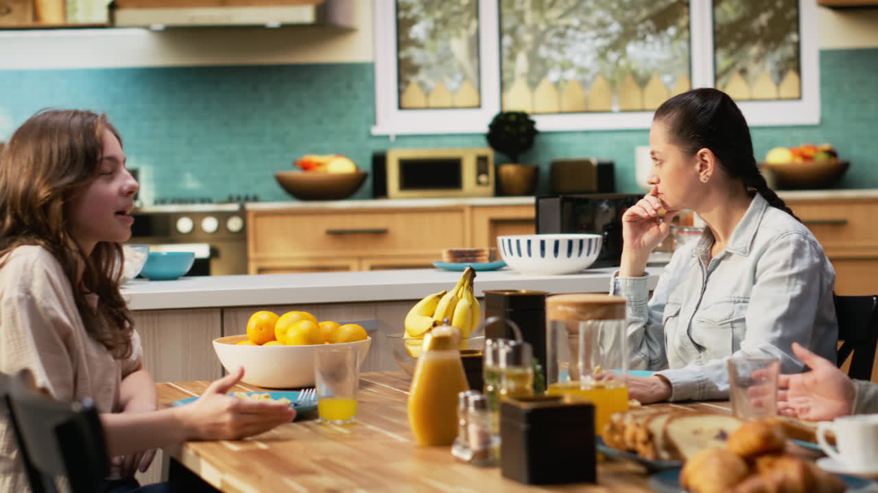 Mother feeling distracted and concerned about her daughter at breakfast