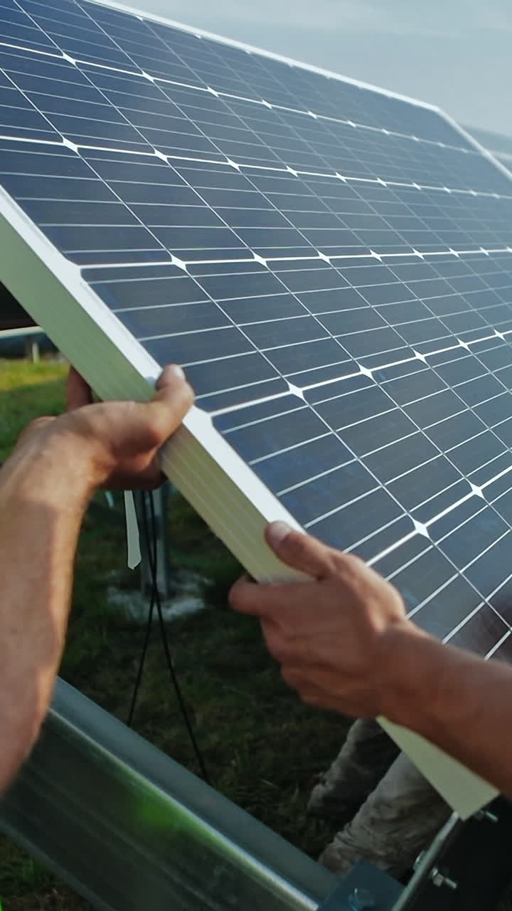 Workers installing solar panels outdoors. Male technicians installing photovoltaic solar panels