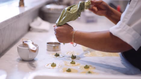 chef mujer tubería tortellini hecho a mano en la cocina, cámara lenta