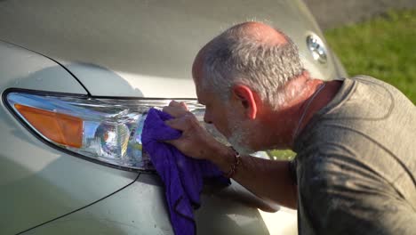 hombre lavando el faro del coche rocía agua en su cara por accidente en cámara lenta