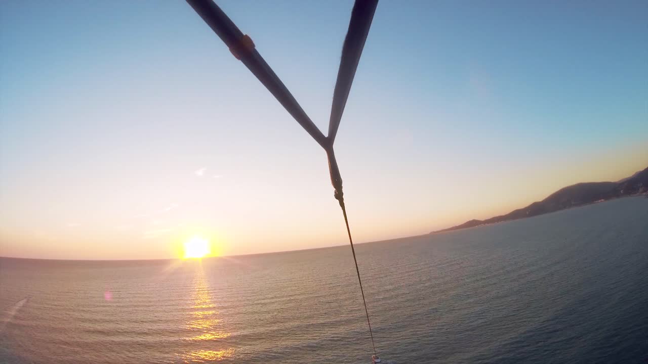 해가 지는 동안 해안선 위에서 패러글라이딩