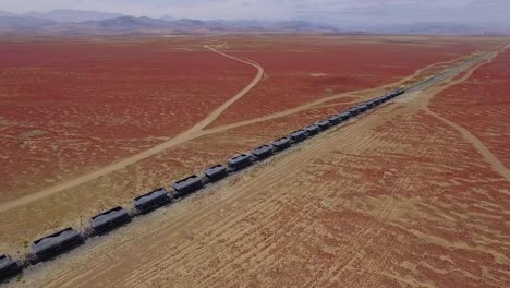 largo tren de carga en un paisaje desértico rojo