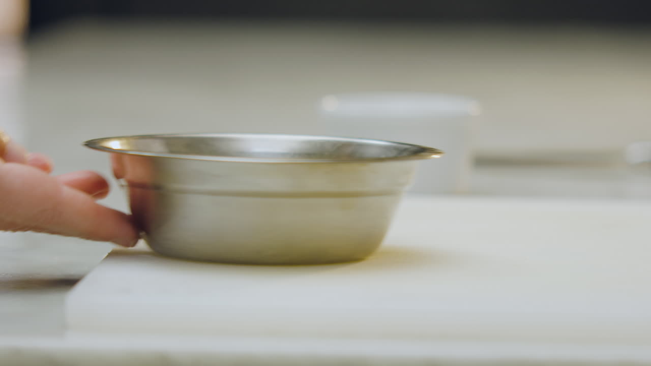 Close-up of a chef gently stirring the ingredients inside an aluminum mold and then bringing a ceramic mold closer to continue the preparation