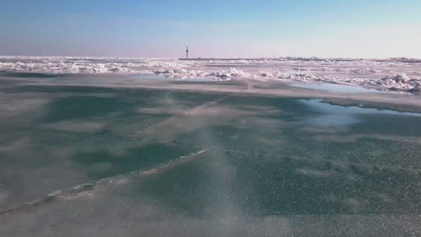 Tiro-Volador-Sobre-Un-Lago-Helado-Para-Revelar-Un-Faro-En-Un-Muelle