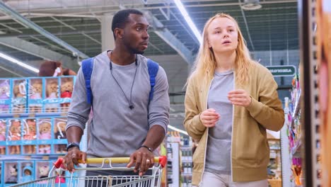 exploring the aisles: a young couple browses through a supermarket, engaging in a lively discussion while shopping for essentials and treats