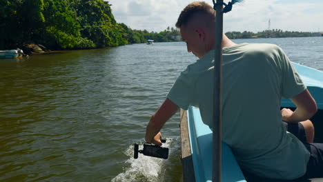 man filming video on a boat on a river