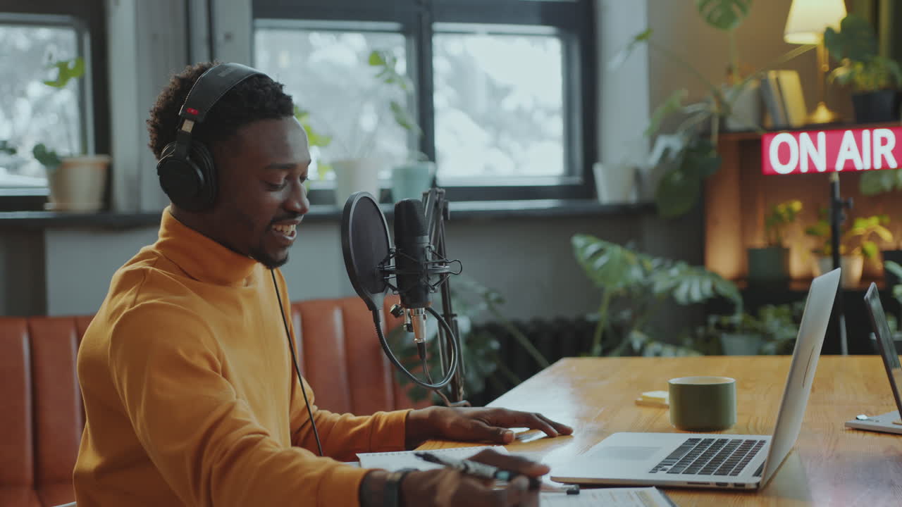 Cheerful Black Podcast Host Recording Interview with Guest in Studio