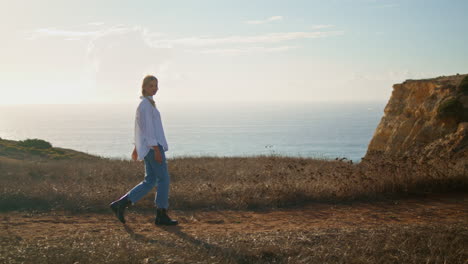 stylish woman exploring coastline alone. blonde woman spending vacation at sea