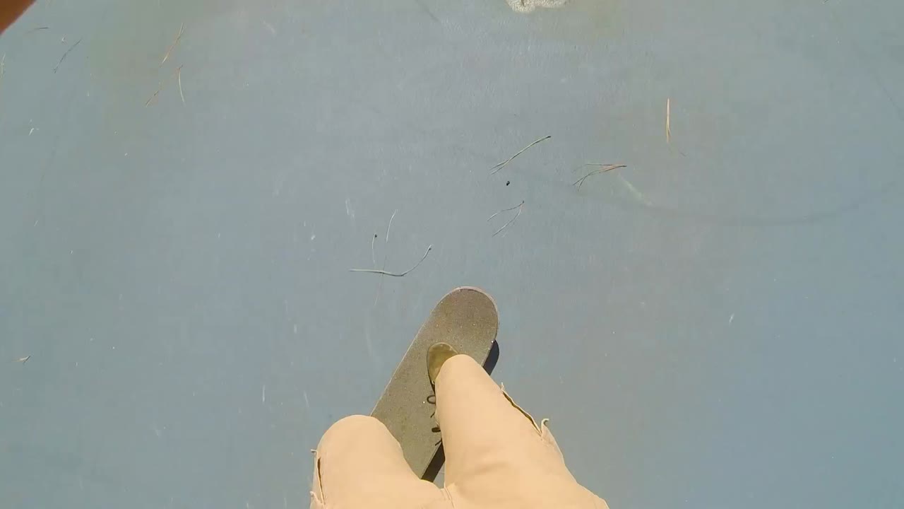 Point of view shot from a skateboarder's perspective, skating at a skate park and doing a smith grind on a rail in the summer.