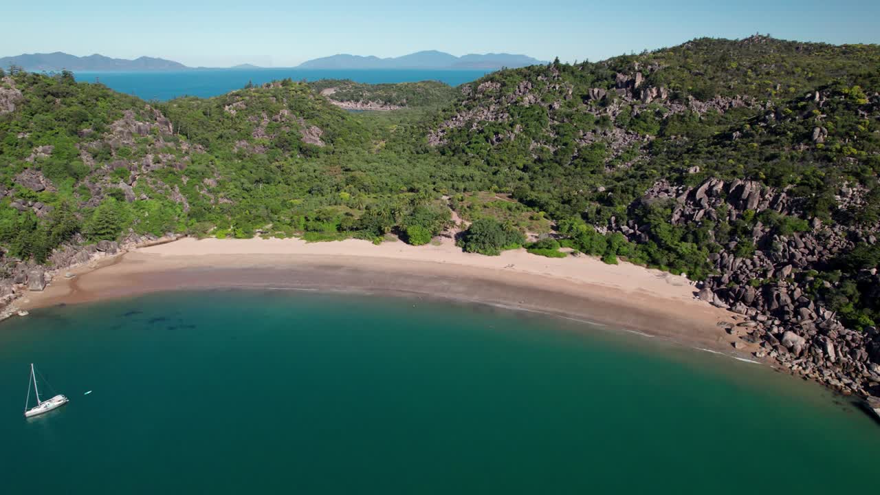 Ripresa drone su Radical Bay a Magnetic Island con una barca in primo piano in una giornata di cielo sereno, Queensland, Australia.