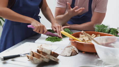 close up of woman chopping fresh herbs for dish in kitchen cookery class