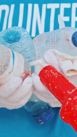 plastic trash in hands of volunteer trying to draw attention to eco problems