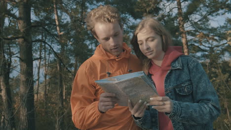 young female and male hikers looking at a map outdoors