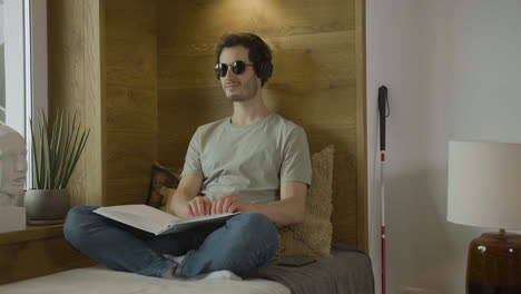 caucasian young man with headphones touching a book