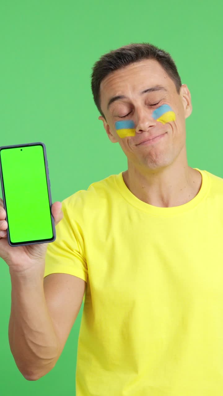 Ukrainian man looking at his mobile smiling and showing it