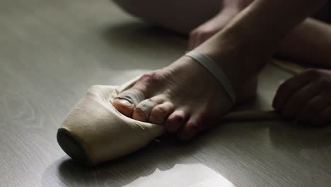 ballerina adjusting pointe shoes