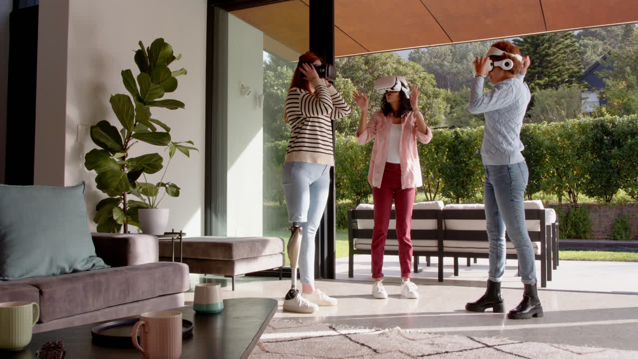 Using VR headsets, diverse female friends enjoying virtual reality in living room