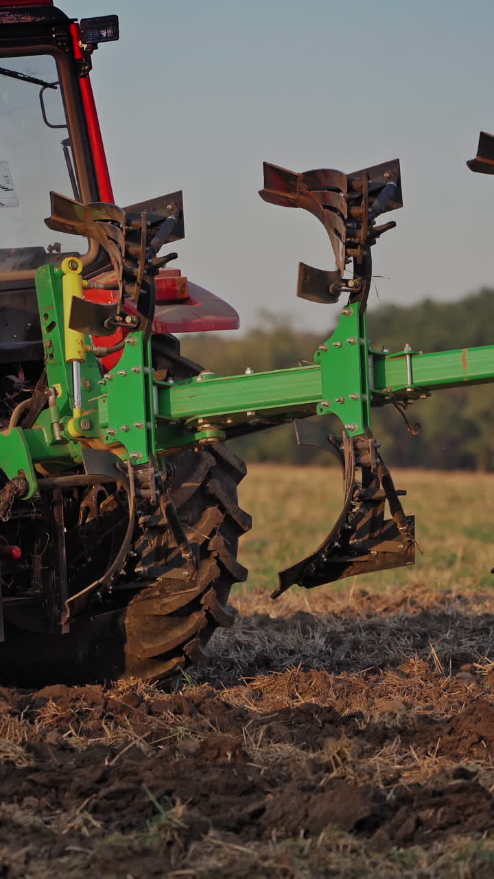 Farmer in tractor customize equipment for cultivating the soil. Close-up view of agricultural tractor in the field at daytime. Seasonal works in rural place. Vertical video