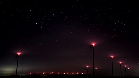 Lapso-De-Tiempo-De-Una-Granja-De-Molinos-De-Viento-Trabajando-En-Una-Noche-Estrellada