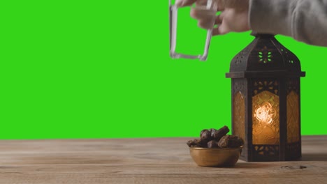 a tracking shot of lantern dates and water in front of a green screen