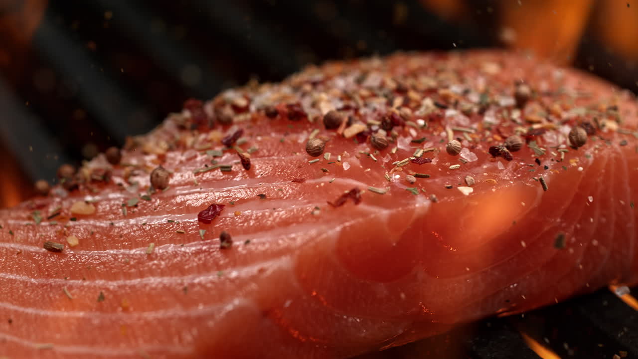 Salmon Fillet Seasoned With Spice Mix in Macro and Slow Motion, Barbecuing On The Grill Among Flames