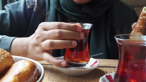 a woman enjoys a traditional turkish breakfast with tea and pastries