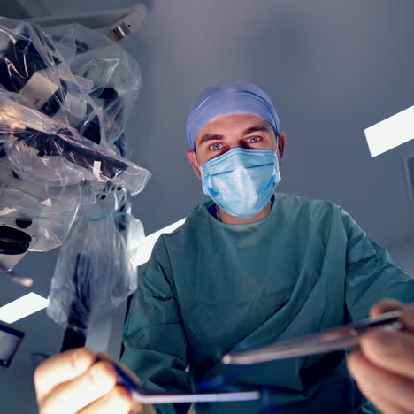 portrait of a surgeon in mask during operation. specialist doctor in medical uniform using special tools during operation process in clinic.