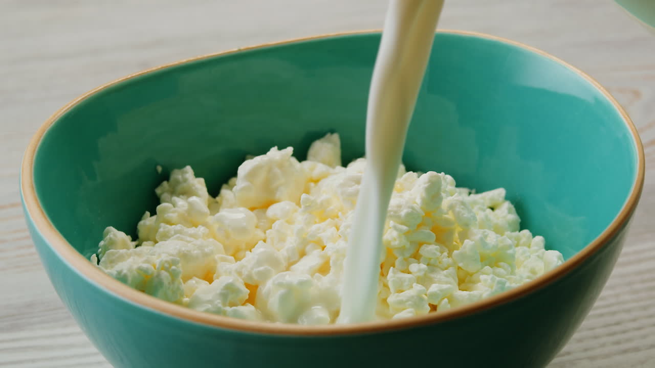 vertiendo leche sobre el queso cottage