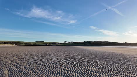 empty sandy beach with frost and morning sun in ireland