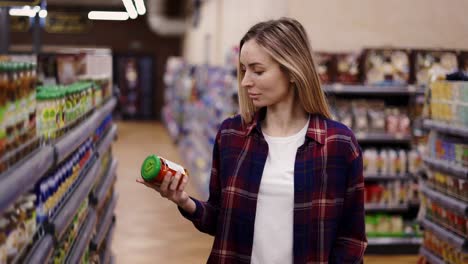 woman buys food at supermarket or grocery shop with shopping cart