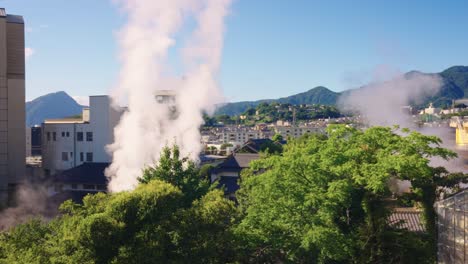 beppu city, onsen and geothermal steam rising over landscape, sunny day, japan